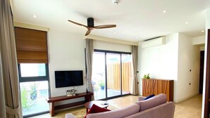 A modern living room with a sofa, a TV, and a ceiling fan. - Apartment Kim Ma (Hanoi)