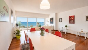 A modern living room with a dining area, large windows, and a view of the sea. - Adelos Coastal Chic by the Sea - Athens Riviera (Alimos)