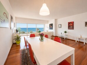 A modern living room with a dining area, large windows, and a view of the sea. - Adelos Coastal Chic by the Sea - Athens Riviera (Alimos)