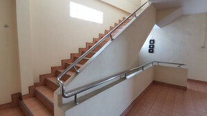 A staircase with metal handrails, a tiled floor, and a small window. - Samran Residence (Krabi)