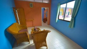 A room with two wicker chairs, a small table, and a window with curtains. - Samran Residence (Krabi)