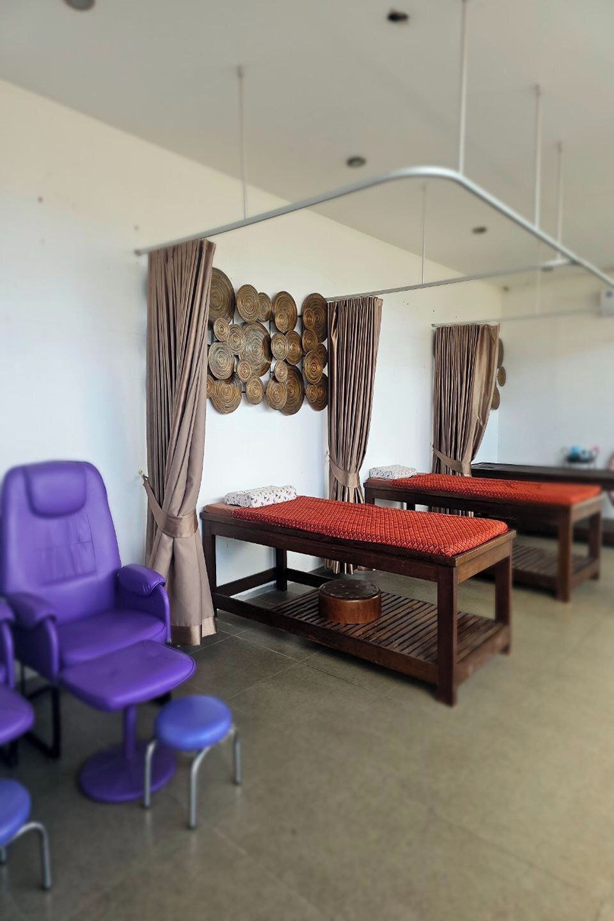 Una habitación con una mesa de madera, sillas moradas y una cortina colgante.