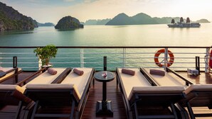 A deck with sun loungers, a small table, and a life buoy. - Orchid Premium Cruises (Hai Phong)