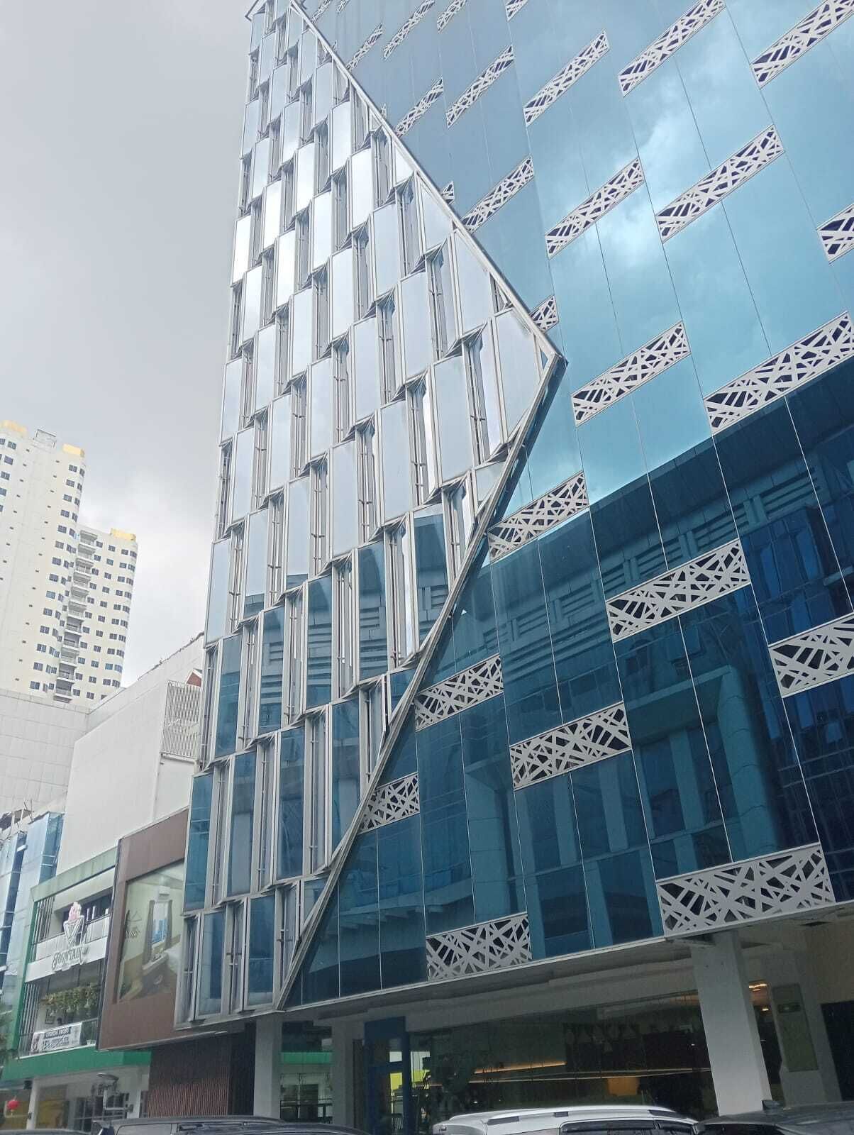 A modern building with a reflective glass facade and geometric window patterns.
