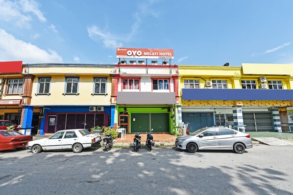 A hotel with a sign reading "OYO MELATI HOTEL" and a green garage door. - OYO 89656 Melati Hotel Nilai (Nilai)