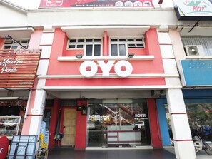 A hotel entrance with a prominent 'OYO' sign, a glass door entrance, and a visible staircase leading inside.