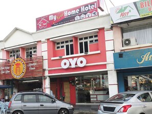 Een hotel met een opvallend 'OYO'-bord, een gevel in rood en wit, en een duidelijke ingang.