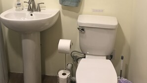Une salle de bain avec un lavabo, des toilettes et un miroir.