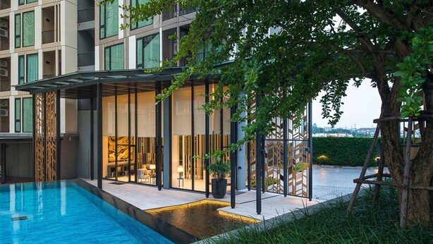 Um hotel moderno com piscina, área de estar ao ar livre e vista para a paisagem urbana.