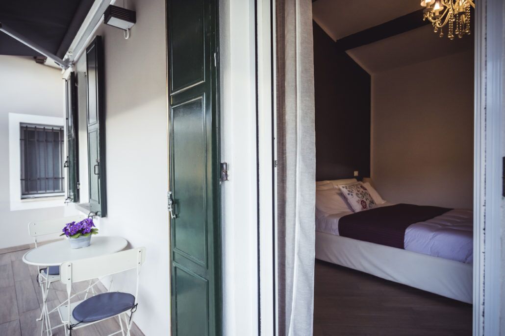 Un dormitorio con una cama, una mesita de noche y una ventana con cortinas.