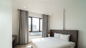 Une chambre d’hôtel moderne avec un grand lit, une table de chevet, une plante en pot et une fenêtre avec des rideaux.