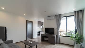 Grand Deluxe King Apartment | Living room | Flat-screen TV