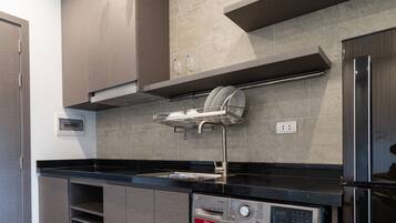 A modern kitchen with built-in appliances, including a washing machine, oven, and microwave.