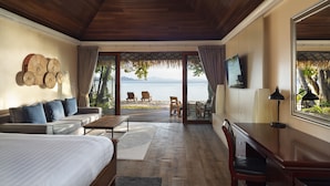 A spacious room with a wooden ceiling, a large bed, a sofa, a desk, and a view of the sea through large windows. - Mali Koh Kradan (Ko Kradan)