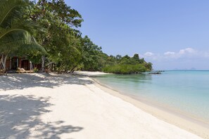 A beach with a wooden structure, clear turquoise water, and lush greenery. - Mali Koh Kradan (Ko Kradan)