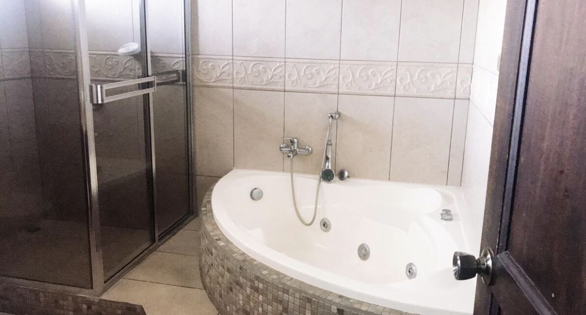 Een bad/douchecombinatie, een haardroger, handdoeken, zeep