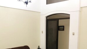 A living room with two brown sofas, a small table, and a dark-colored door leading to another room. - Beautiful House, Master Bedroom With A Jacuzzi, Private Balcony, Mountain View! (El Tejar del Guarco)