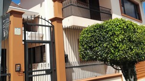A two-story house with a gated entrance, a balcony, and a well-maintained hedge. - Beautiful House, Master Bedroom With A Jacuzzi, Private Balcony, Mountain View! (El Tejar del Guarco)
