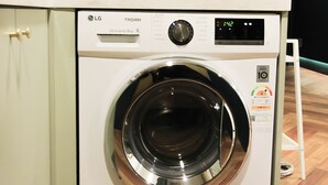 Una unidad de lavadora y secadora compacta con pantalla digital, un panel de control pequeño y una puerta de acero inoxidable.