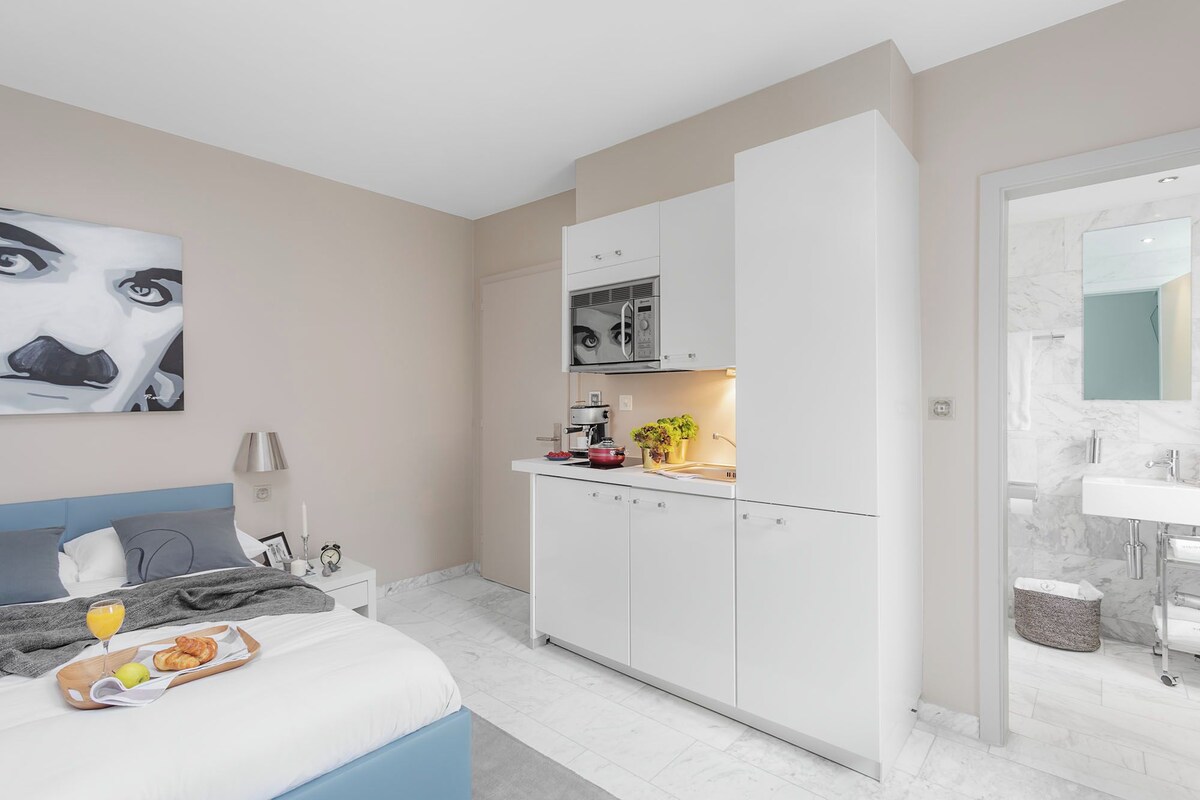 A modern bedroom with a bed, bedside table, and a breakfast tray.