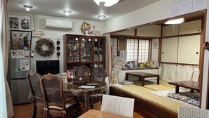 Una sala de estar tradicional japonesa con suelo de tatami, una mesa de madera baja y una zona de estar integrada.