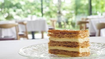 A stack of layered dessert on a clear glass plate.
