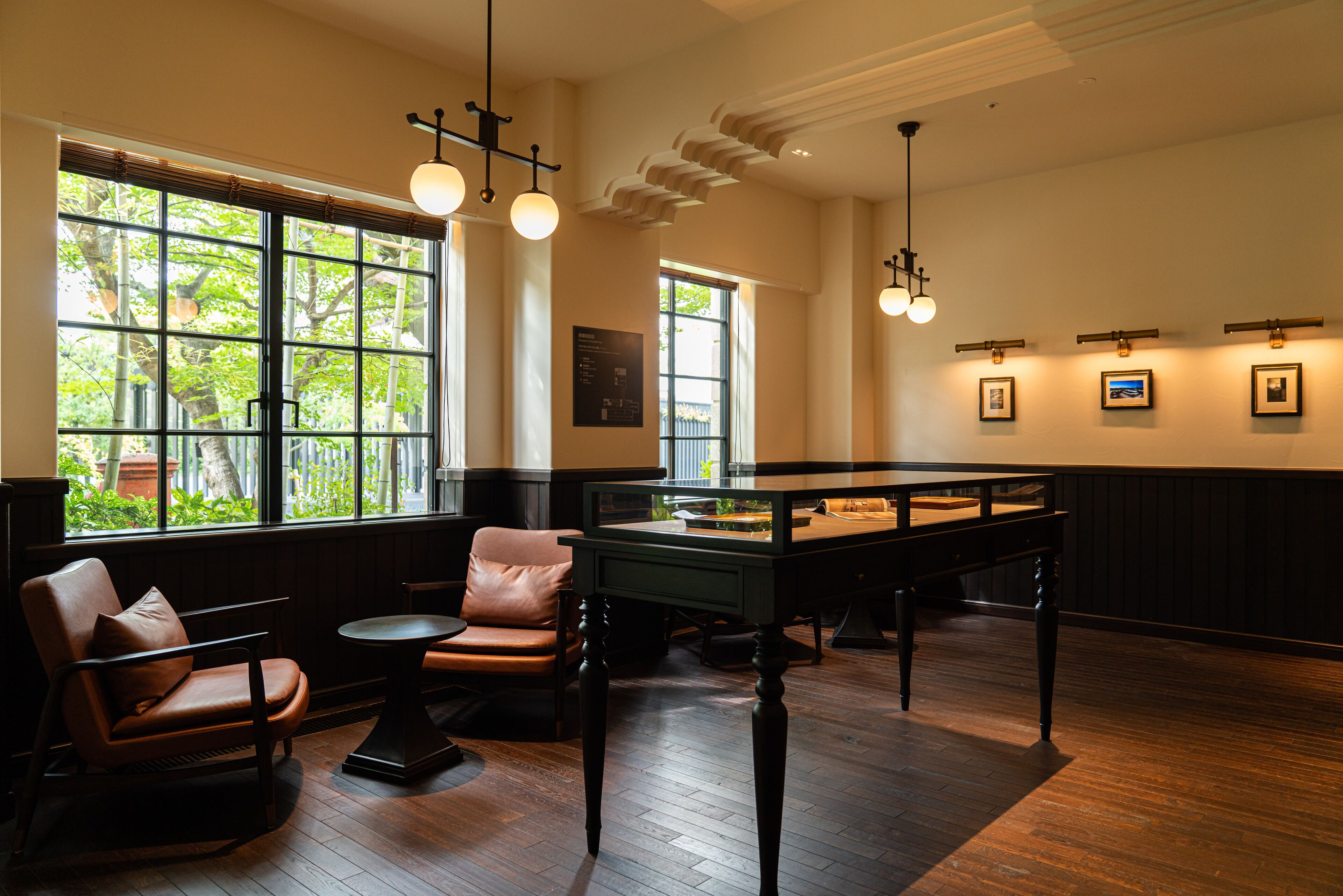 Una habitación con mesa de billar, sillas de cuero y ventanas amplias que dejan entrar luz natural.