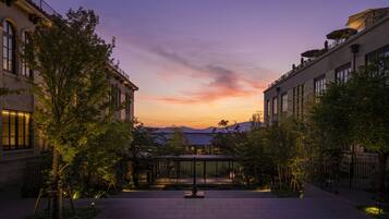 A courtyard with a glass gazebo, surrounded by trees and buildings with large windows.