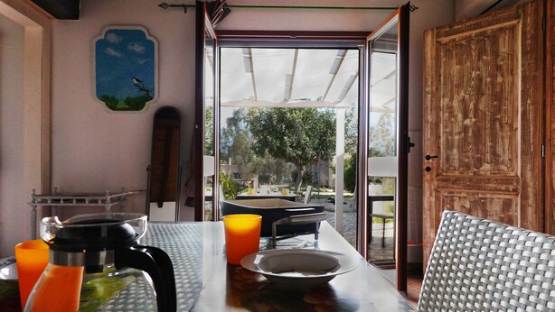 A dining area with a table, chairs, a coffee maker, and a glass of orange juice. - "Pride and Prejudice" - Residences Gattopardu (castiadas)
