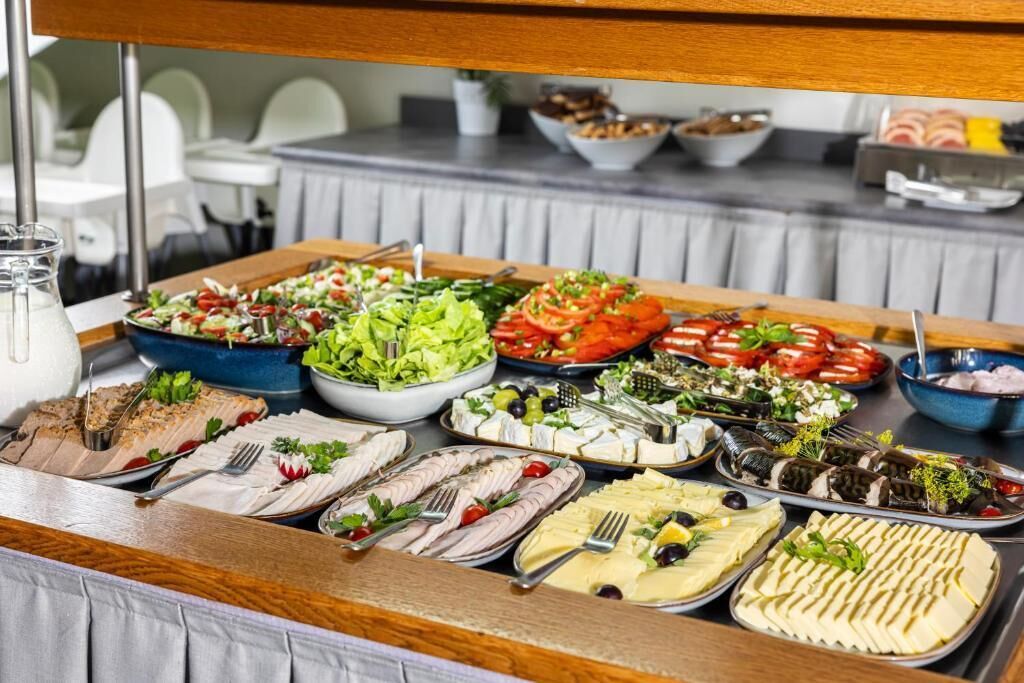 A buffet with various food options including salads, meats, and cheeses.