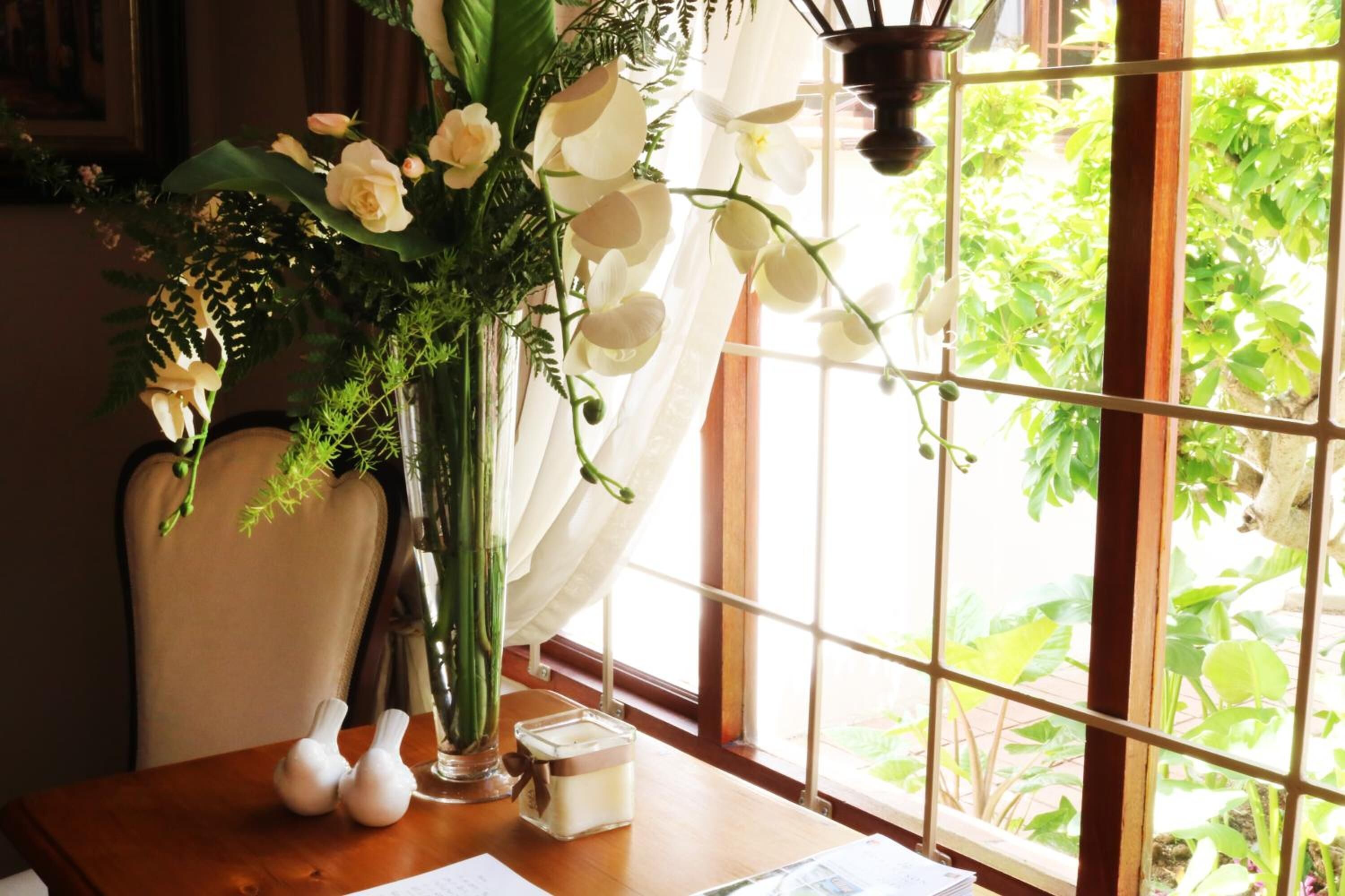 A table with a vase of flowers, a candle, and a small decorative item.