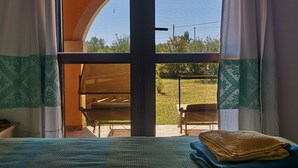 Une chambre avec un lit, une vue sur un patio extérieur et un plafond en bois.