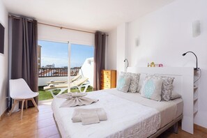 A bedroom with a bed, a chair, a dresser, and a view of the outside. - Home2Book Paradise Costa Adeje, Pool (Playa de las Americas)