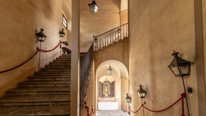 A grand staircase with a red rope barrier, leading to an arched doorway. - Ajutamicristo by DomuSicily (Palermo)