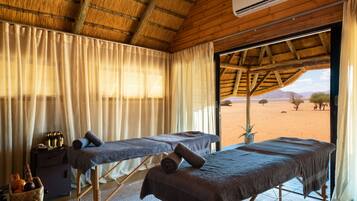 Relax in a serene space with a thatched roof ceiling and stunning desert views.