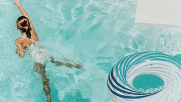A person swimming in a pool with a ring float.
