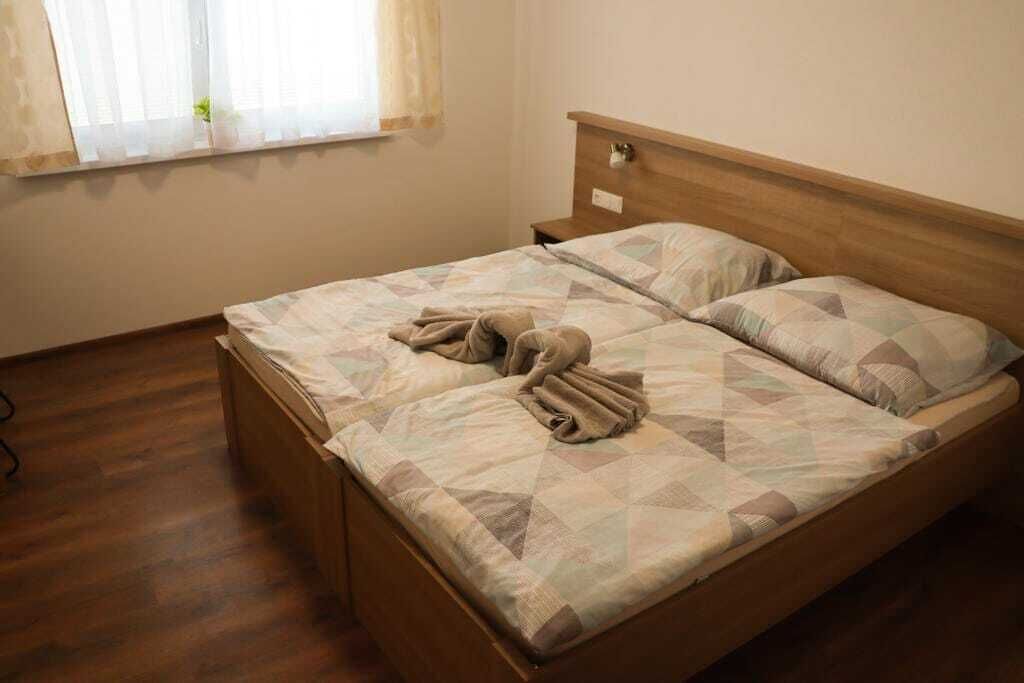 Ein Einzelbett mit Holzrahmen und gesteppter Bettdecke.