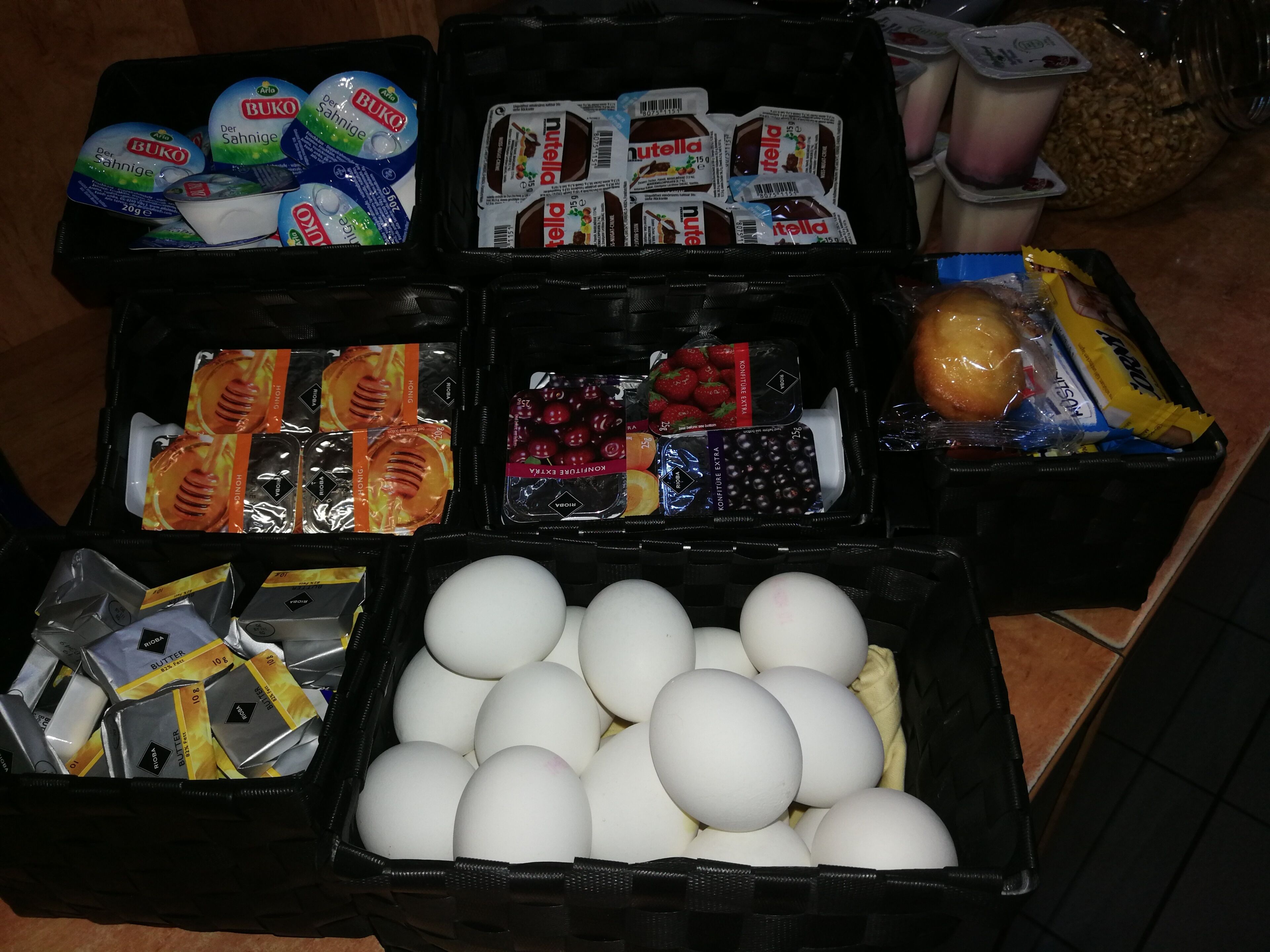 A variety of food items including yogurt, Nutella, honey, and eggs in a kitchen setting.