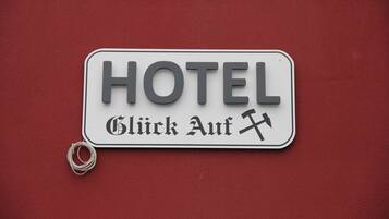 A hotel sign with the word "HOTEL" and the phrase "Click Auf" in German, indicating a clickable button or interactive element.