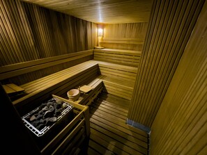 A sauna with wooden benches and a stone basin. - Erciyes Hill Hotel (Kayseri)