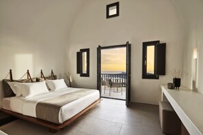 A bedroom with a bed, a balcony, and a desk.