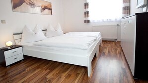 A bedroom with a bed, bedside table, lamp, and a painting on the wall. - Holiday home Findling Summer - House Findling (Sankt Lambrecht)