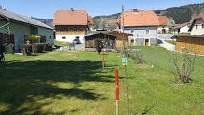 A residential area with houses, a grassy lawn, and a clear sky. - Holiday home Findling Summer - House Findling (Sankt Lambrecht)
