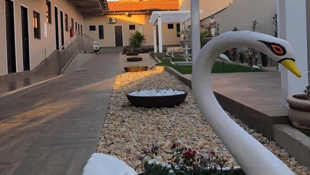 Una estatua de cisne en un patio con un edificio al fondo.