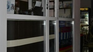 A corridor with glass-fronted rooms, a vending machine, and a blue and yellow banner. - OK Apartment (Kyiv)