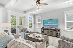 A spacious living room with a ceiling fan, a large flat-screen TV, and a comfortable seating area with sofas and chairs. - 3,000+ Sq Ft! 5 Bikes! 3 King Suites- Serenity Pond at NatureWalk on 30A (Santa Rosa Beach)