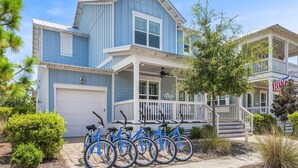 A two-story house with a porch and a garage. - 3,000+ Sq Ft! 5 Bikes! 3 King Suites- Serenity Pond at NatureWalk on 30A (Santa Rosa Beach)