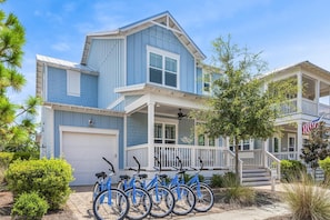 A two-story house with a porch and a garage. - 3,000+ Sq Ft! 5 Bikes! 3 King Suites- Serenity Pond at NatureWalk on 30A (Santa Rosa Beach)