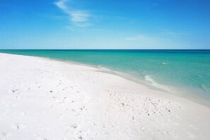 Una playa con arena blanca y agua turquesa cristalina.