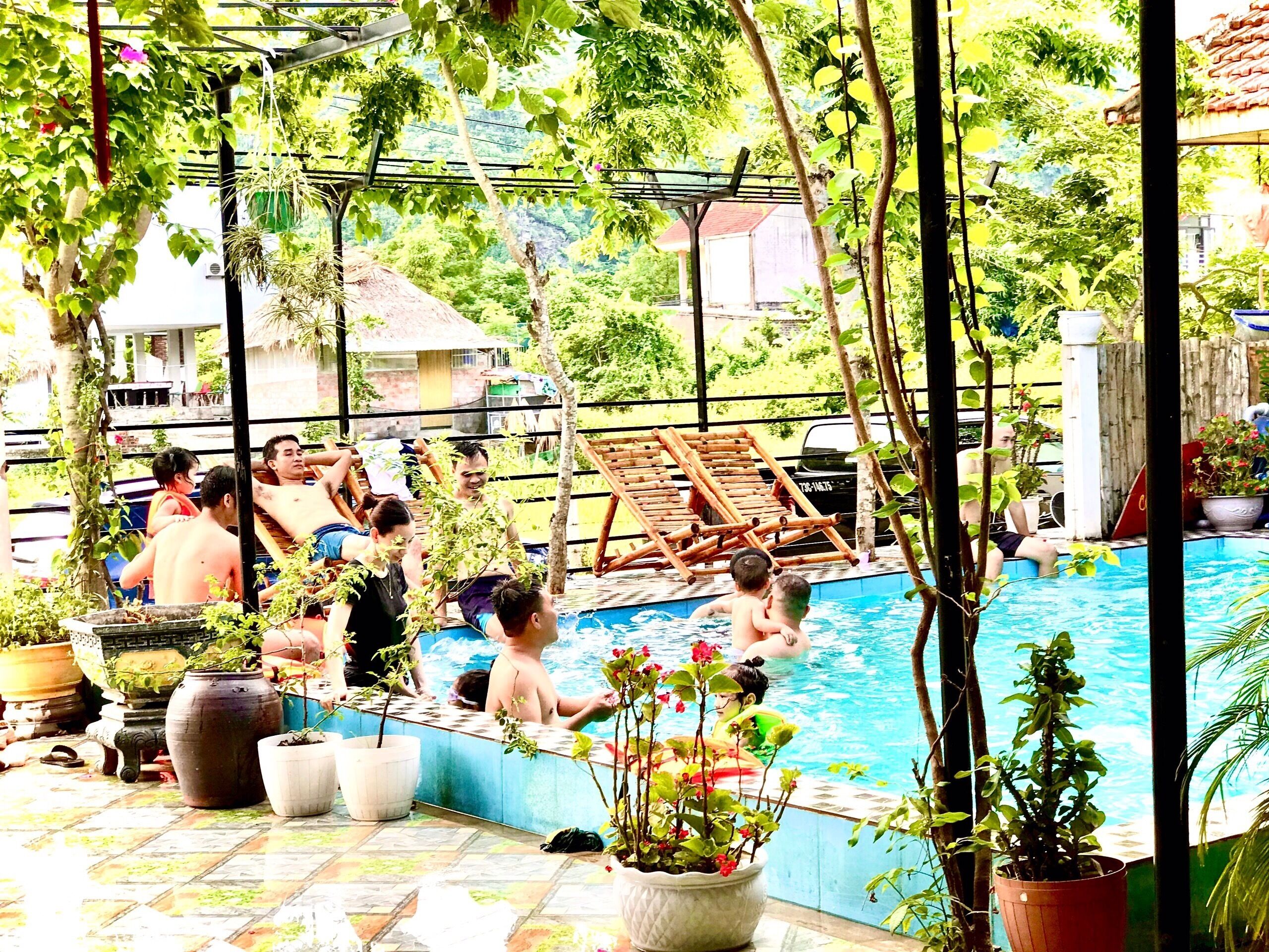 A pool area with lounge chairs and potted plants.